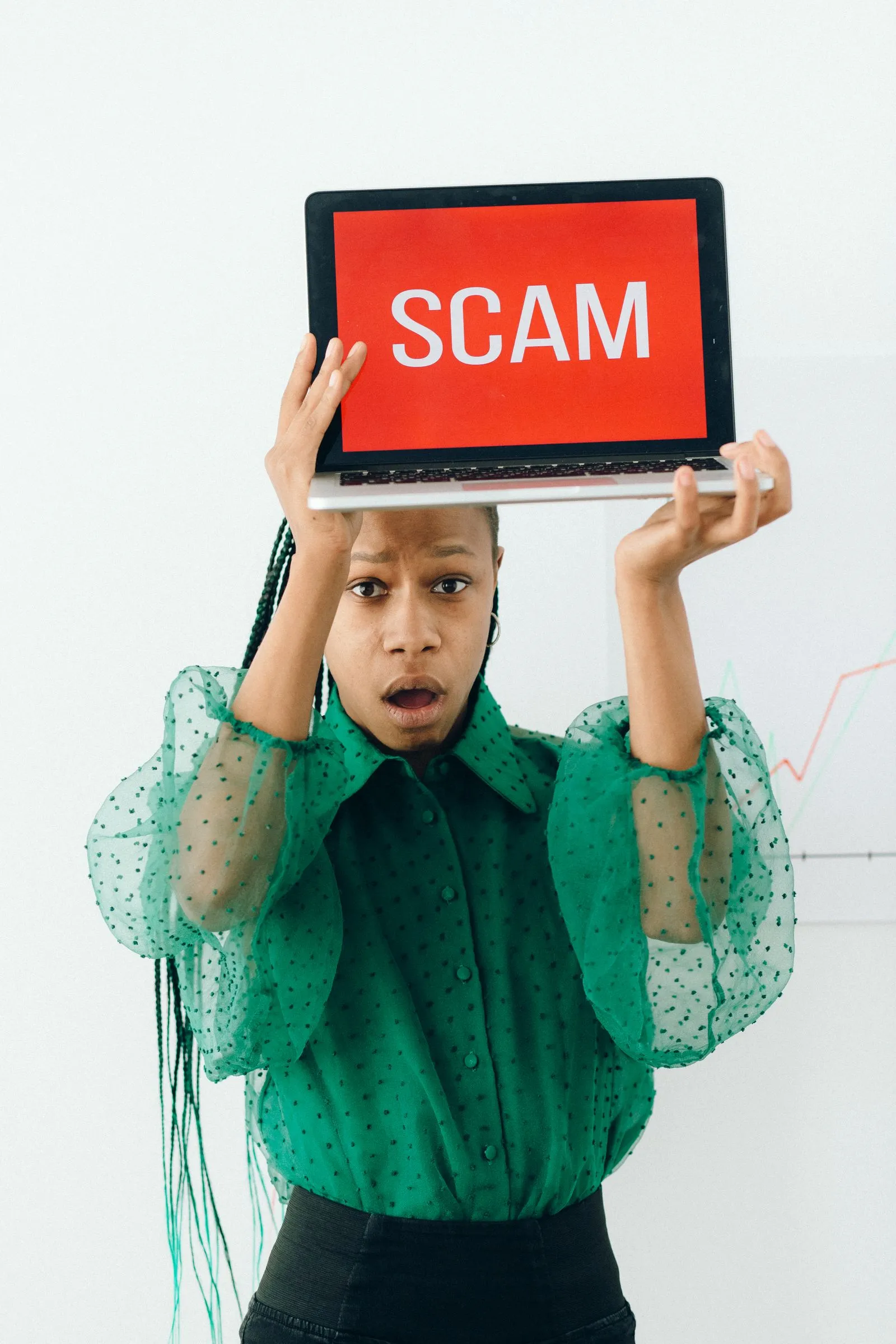 Remote worker holding a laptop with a scam warning on screen